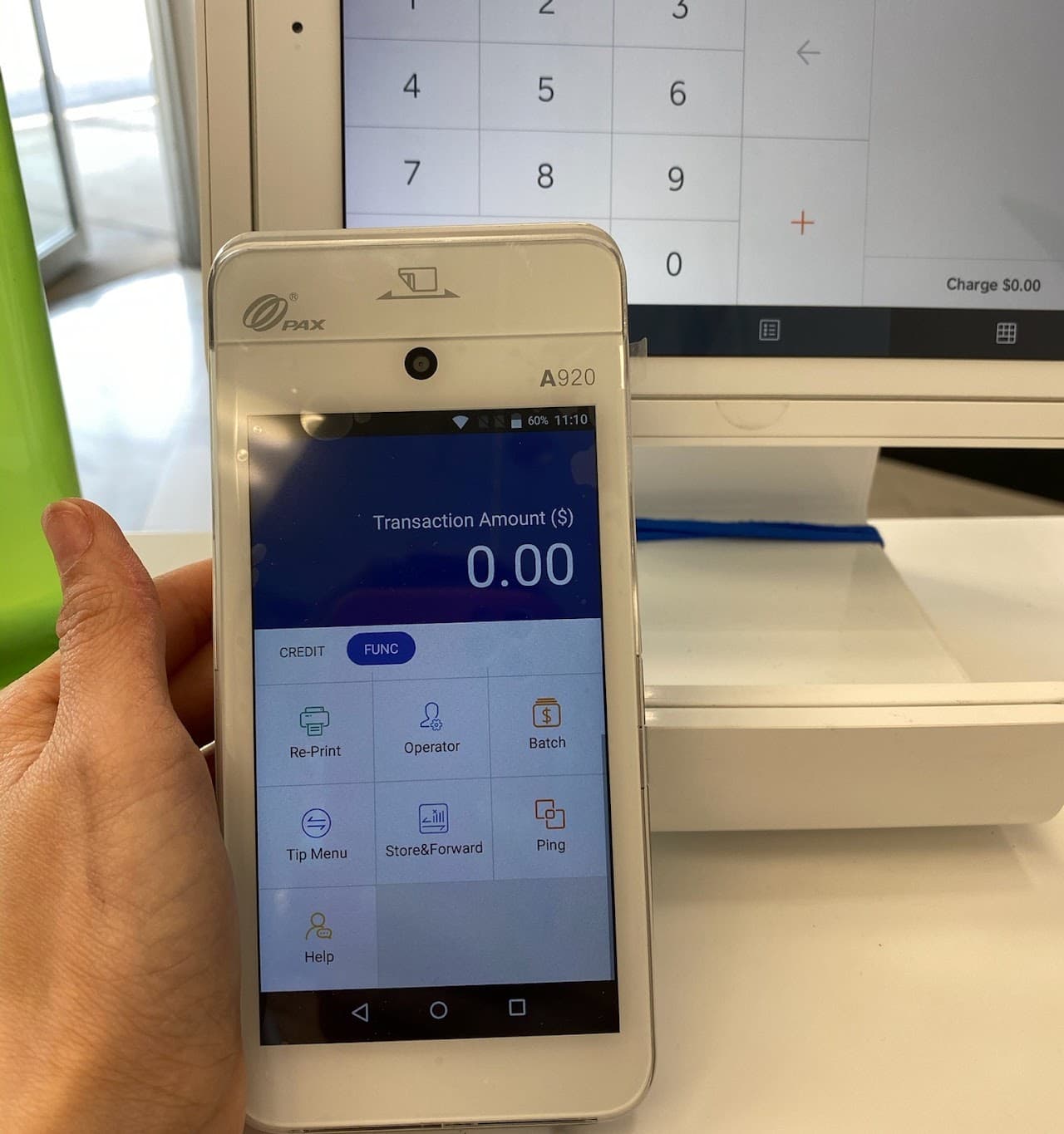 Handheld payment terminal shown with a point-of-sale screen